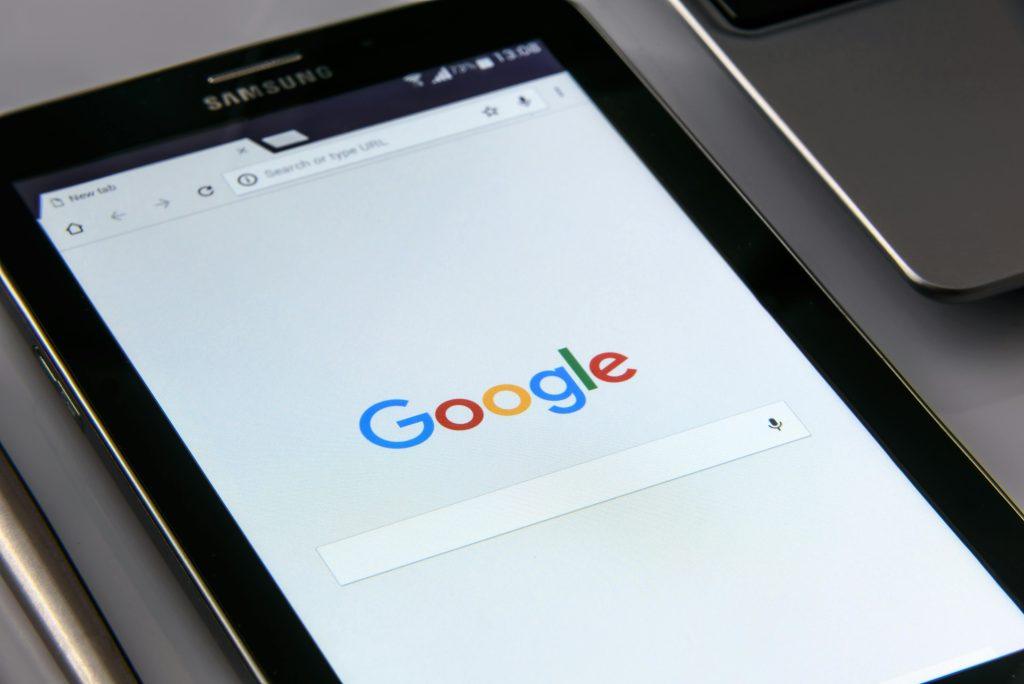 Tablet mostrando a Google y un dominio gratuito