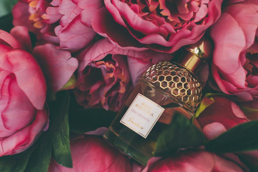 Imagen de un perfume en unas rosas