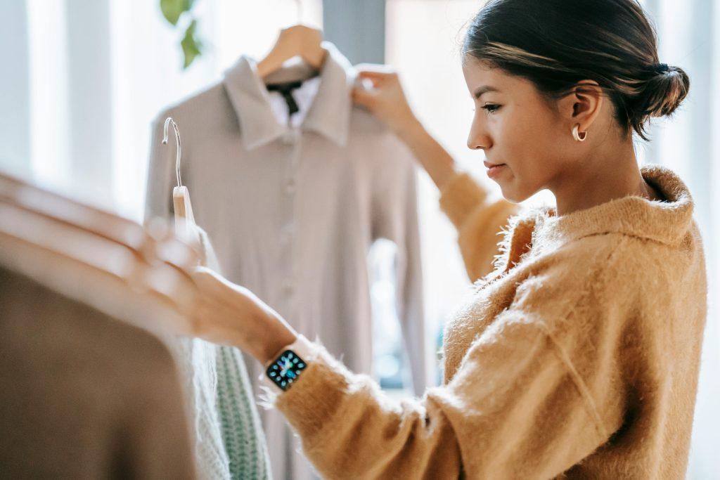 Chica colocando su ropa para vender en su mostrador