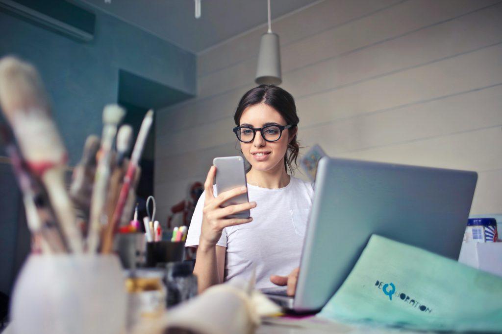 Chica con gafas, usando su teléfono