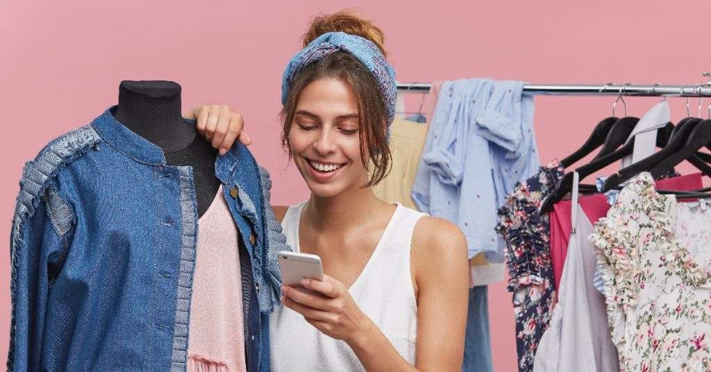 Chica feliz, haciendo fotos de su ropa antes de venderla