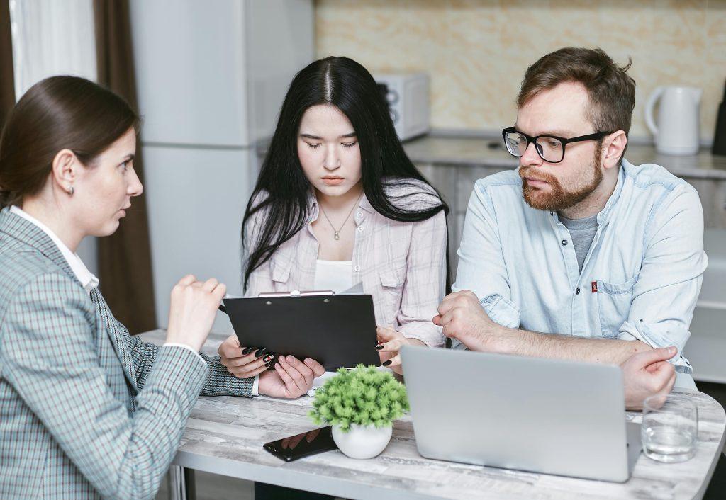 Tres personas mirando una table, planificando sus estrategias para hacer un buen marketing para su feria.