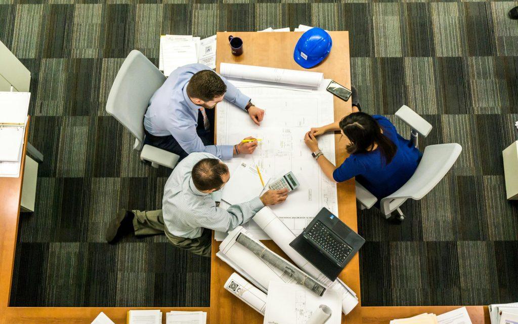 Personas sentadas en una mesa pensando cómo gestionar un proyecto