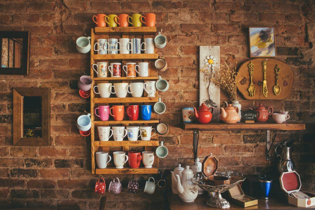 Una imagen de una pared con diferentes tazas de muchos colores.