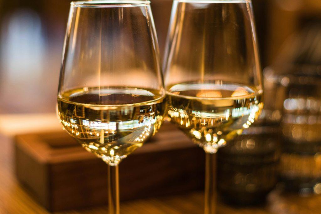 Dos copas de vino blanco en un local elegante y muy romántico