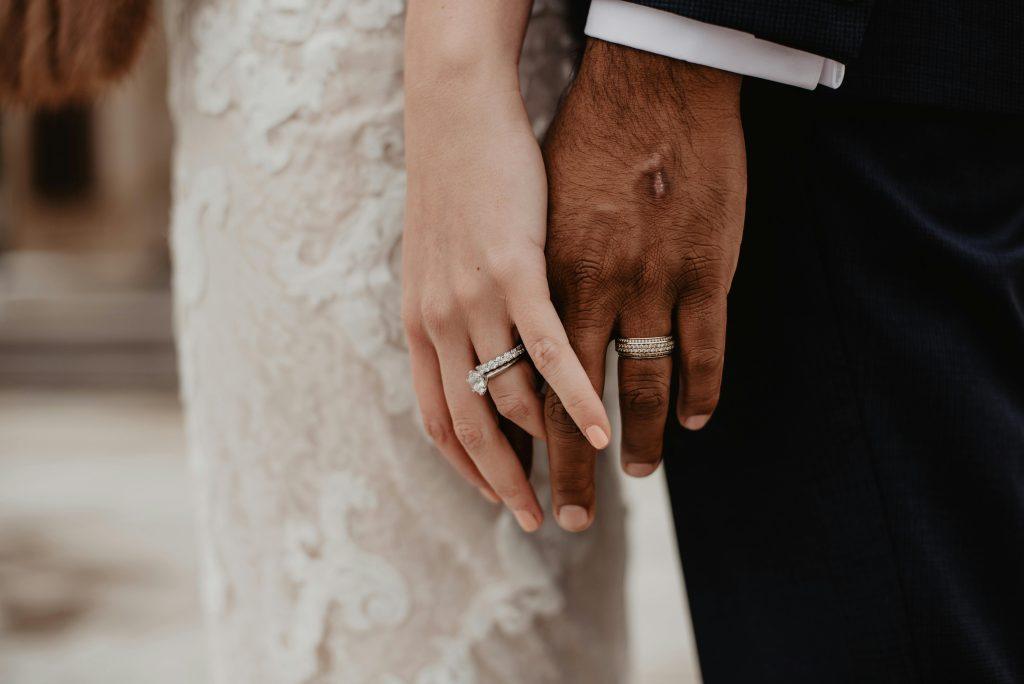 Una pareja de novios con sus anillos de compromiso, yendo al altar