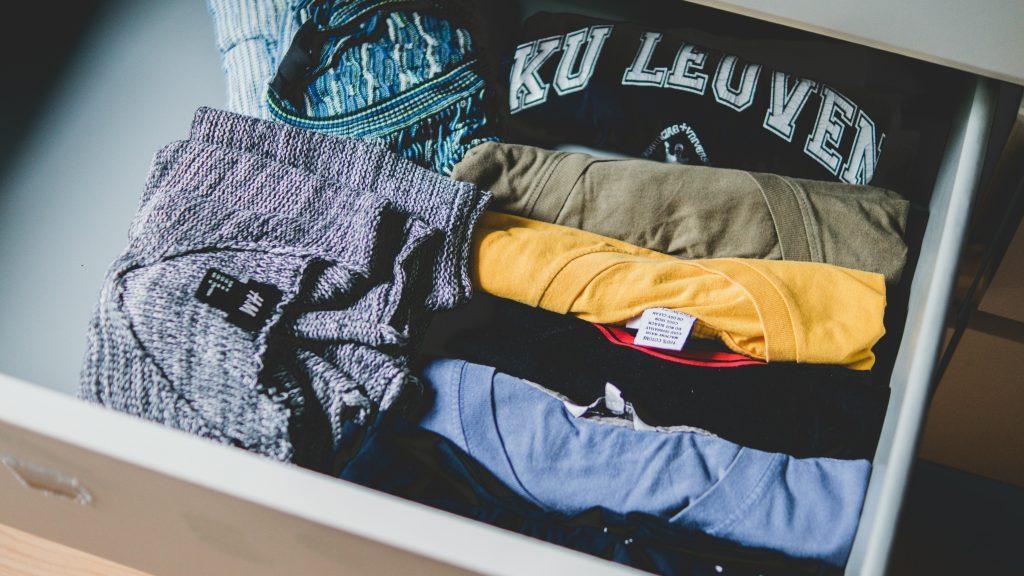 Un cajón con camisas de diferentes colores.