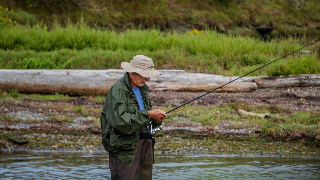 Un padre difícil de contentar pescando con la caña que le han regalado