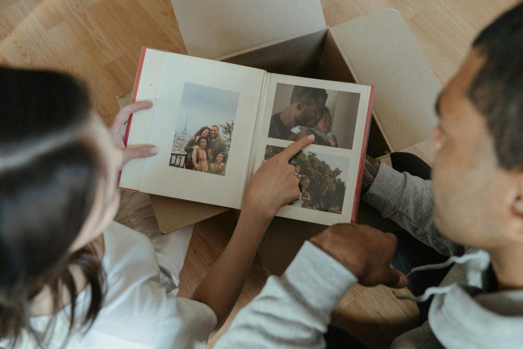 Una pareja de futuros mirando su nuevo regalo, un álbum de fotos con sus imágenes.