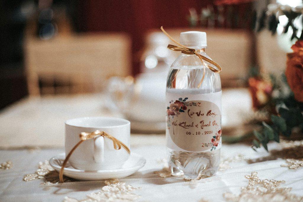 Una botella de plástico, personalizada en una mesa llena de artículos de navidad.