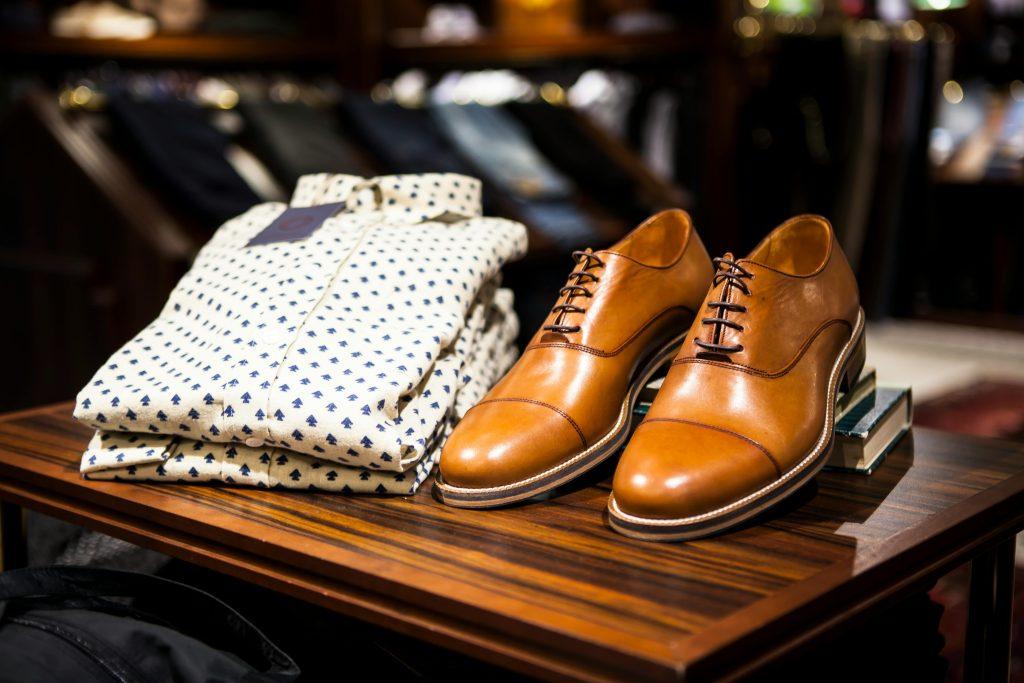 Una camiseta, al lado de unos zapatos de cuero que se han vendido como ropa en el Shein.