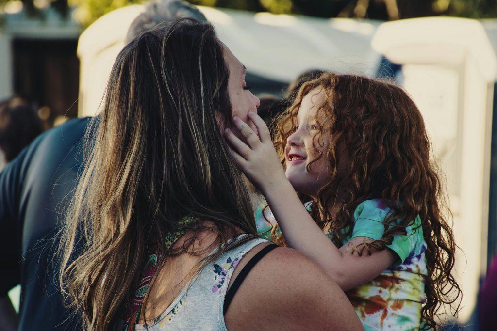 Una mujer con su hija, dándose amor