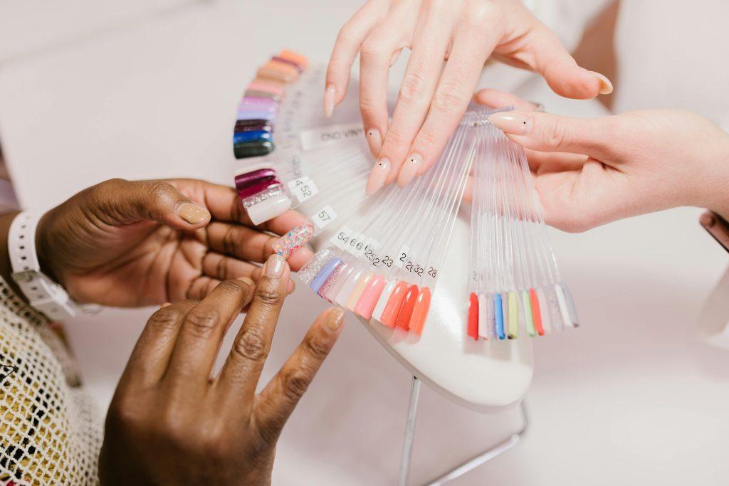 Chicas mirando colores de uña y decidiendo nombre para su negocio de uñas