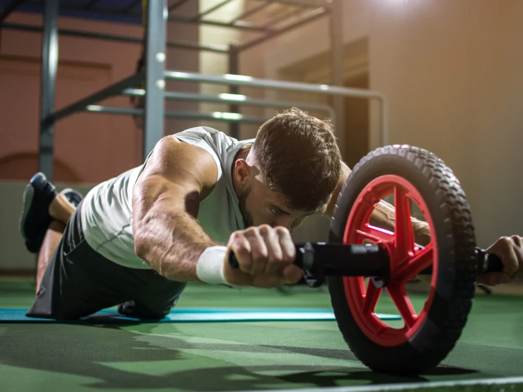 Un hombre con su regalo para el gimnasio una rueda para estiramientos