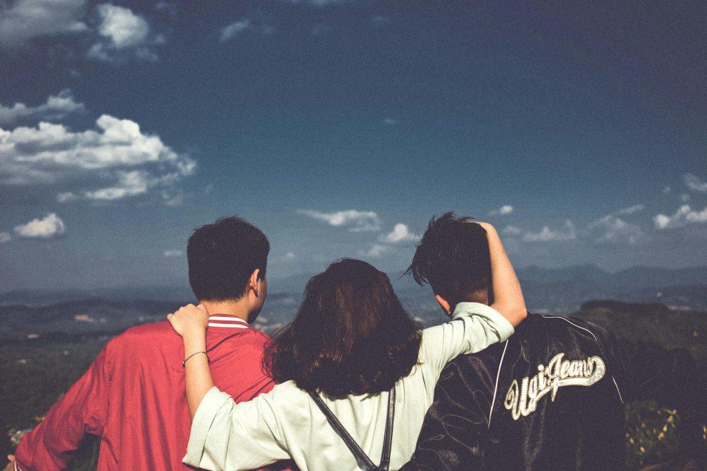 Un grupo de tres amigos mirando el horizonte.