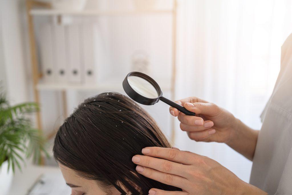 Un médico mujer diagnosticando calvicie a una mujer y recetándole vitaminas para la caída del cabello.