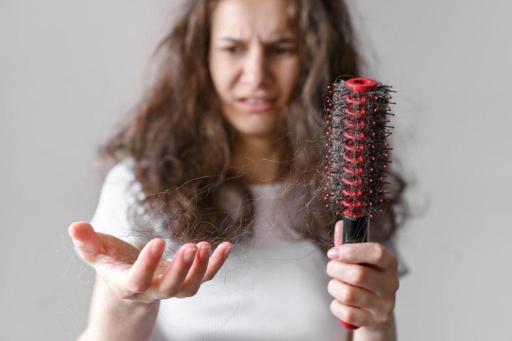 Una mujer con el pelo destrozado y poroso, buscando un producto para aplicarse un tratamiento.