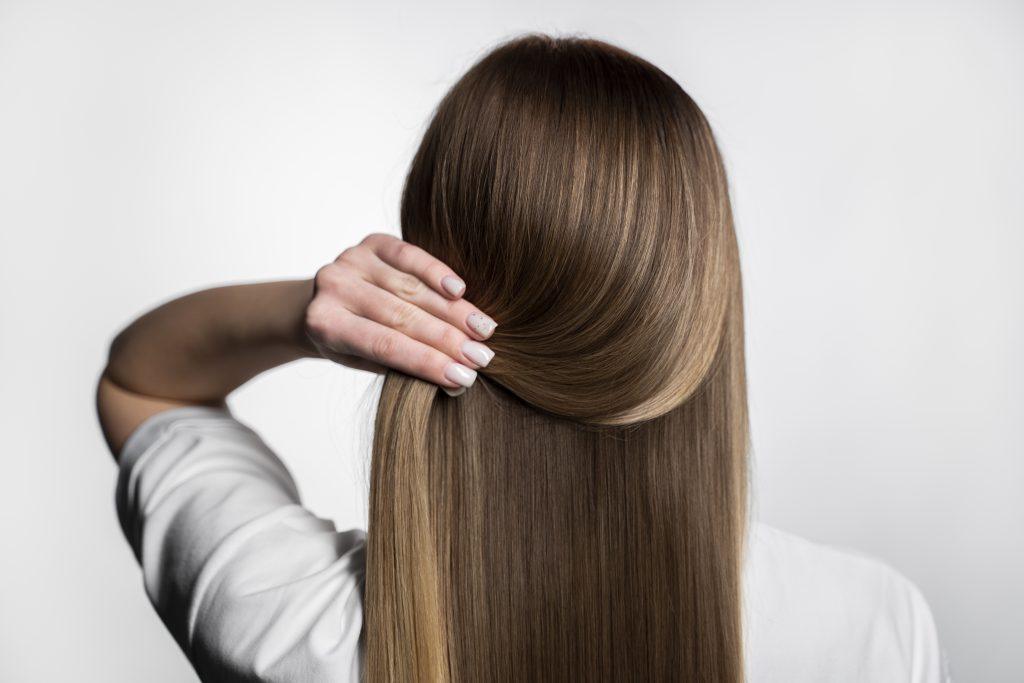 Una chica recogiendo su cabello castaño