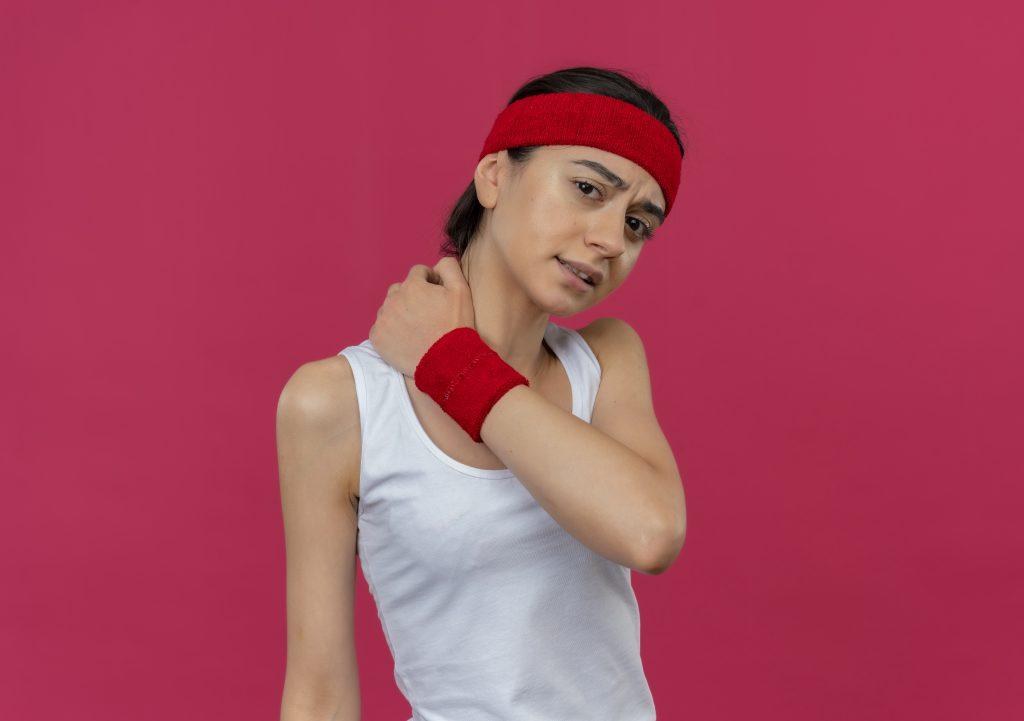 Una mujer dolorida, con dolor en el cuello con un fondo rojo.