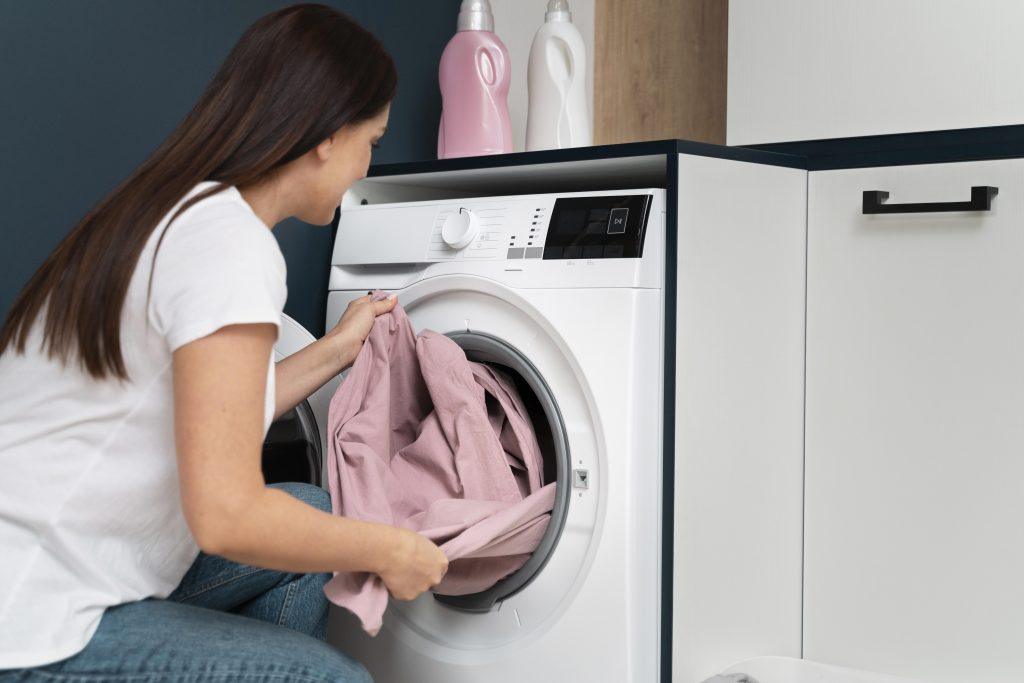 Una chica colocando ropa en su lavadora a+++ nueva