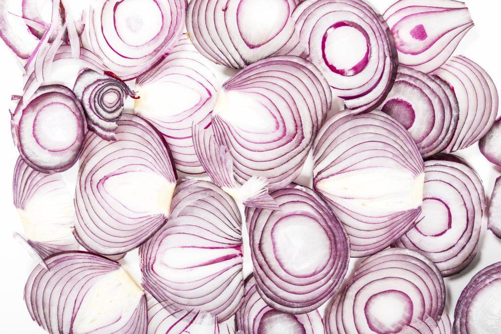 Una imagen de diferentes rodajas de cebolla morada