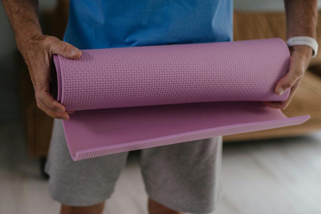 Un hombre enrollando una cinta morada del gimnasio