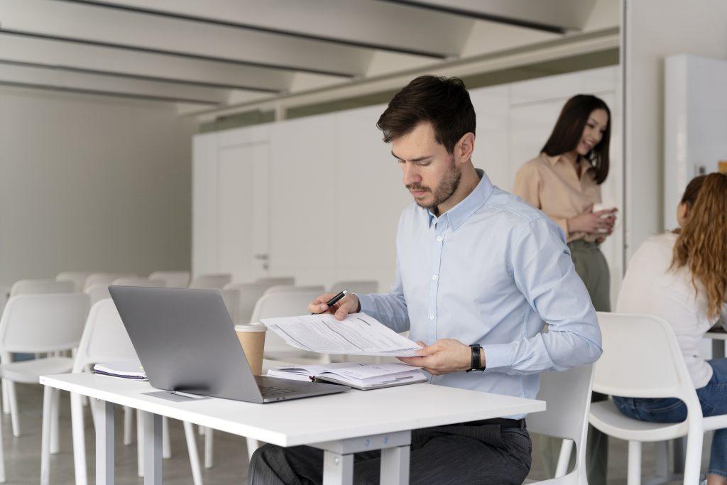 Un hombre en el trabajo, mirando unos documentos en la oficina.