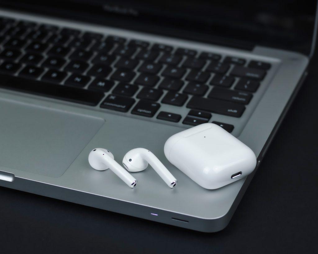 Unos auriculares inalámbricos apoyados en un ordenador listos para conectarse a la TV por personas mayores
