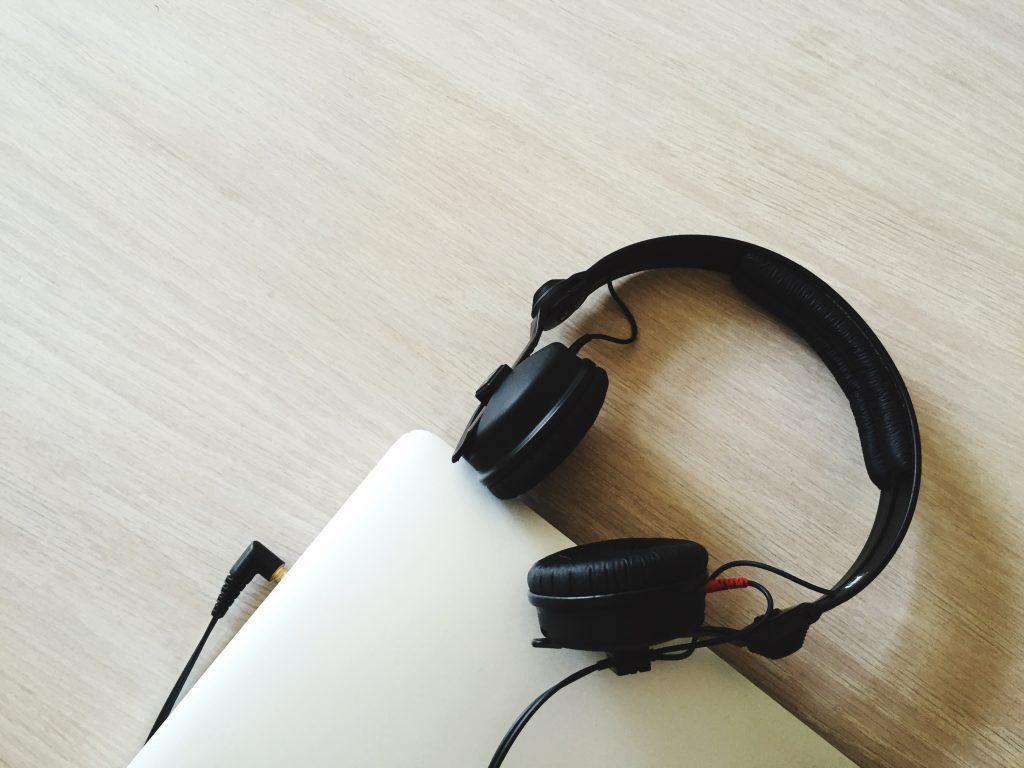 Unos cascos grandes bluetooth conectados a un portátil.