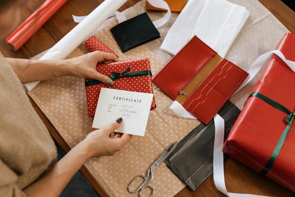 Una mujer poniendo una carta personalizada en un regalo para su amiga